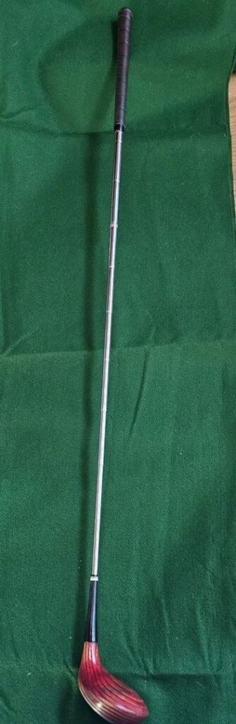 Vintage wooden-shafted golf club with a red-stained head